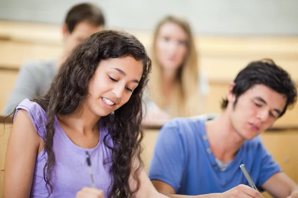 Smiling students writing Royalty Free Stock Images