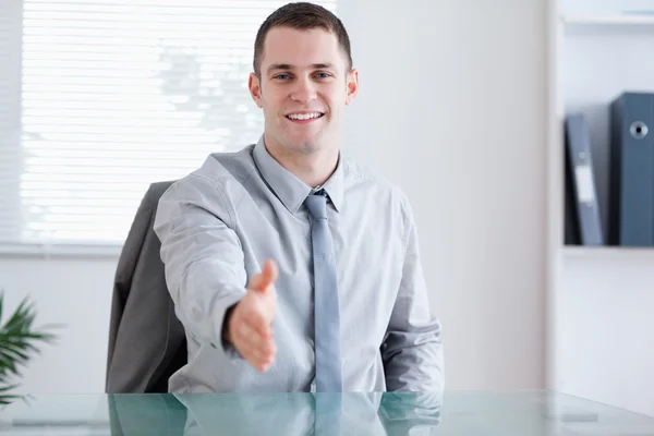 Un uomo d'affari sorridente saluta il suo partner di negoziazione Immagine Stock