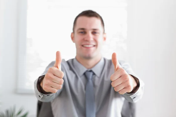 Young businessman giving thumbs up Stock Image