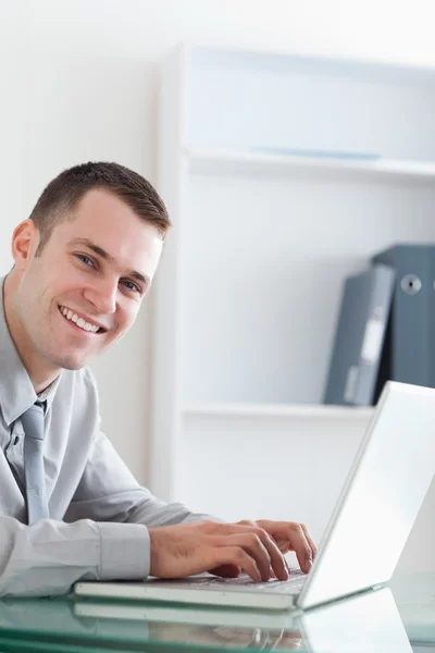 Happy businessman typing on his laptop Stock Image