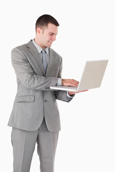 Portrait d'un jeune homme d'affaires travaillant avec un ordinateur portable Image En Vente