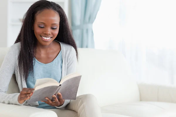 Woman on sofa with book Stock Photo