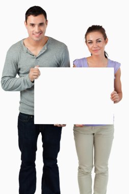 Young couple holding banner together clipart