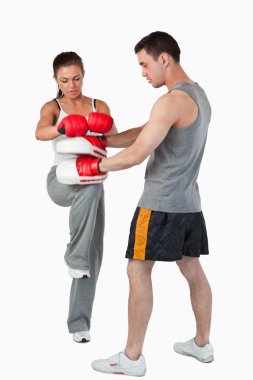 Young female martial arts fighter practicing her knee technique clipart