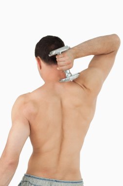 Back view of young male with dumbbell clipart