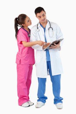 Portrait of a nurse showing something to a doctor clipart