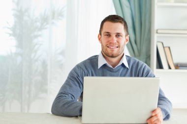 Man with his notebook in his homeoffice clipart