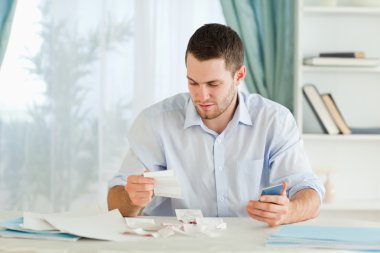 Businessman with calculator checking bills clipart