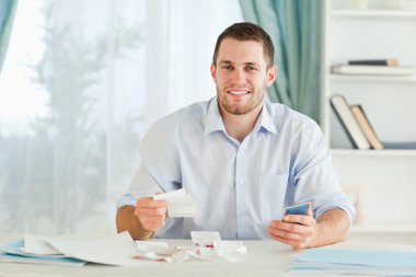 Businessman with pocket calculator checking bills clipart