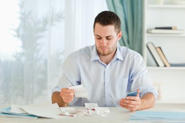 Businessman with pocket calculator checking invoices clipart