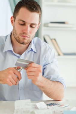 Businessman using scissor to destroy his credit card clipart