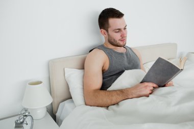 Young man reading a novel clipart