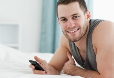 Smiling man using his mobile phone clipart