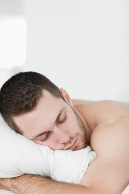 Portrait of a man lying on his belly while sleeping clipart