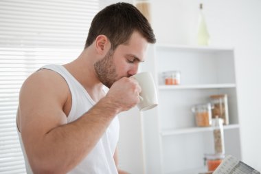 Man drinking coffee while reading the news clipart