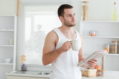 Dreaming man drinking coffee while reading the news clipart