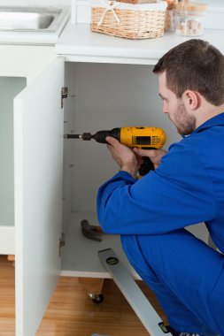 Portrait of a handyman fixing a door clipart