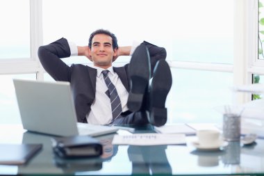 Smiling businessman relaxing clipart