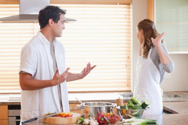 Couple has a tensed situation in the kitchen clipart