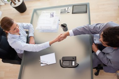 Above view of consultant shaking hands with customer clipart