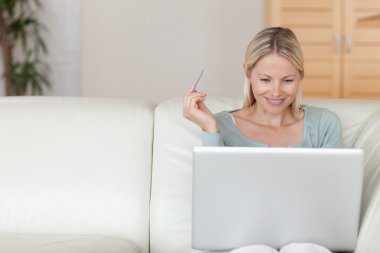 Woman shopping online on the sofa clipart