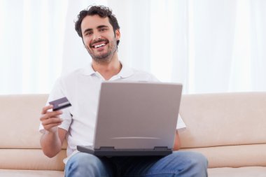 Smiling man buying online clipart