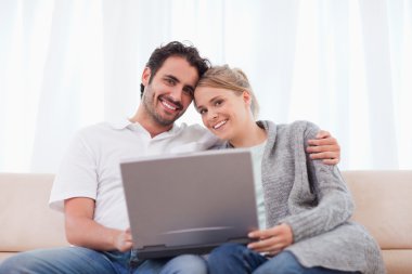 Cute couple using a laptop clipart