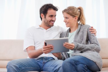 Young couple using a tablet computer clipart