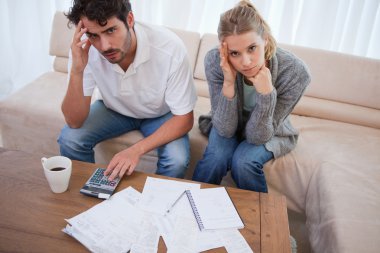 Worried couple doing their accounting clipart