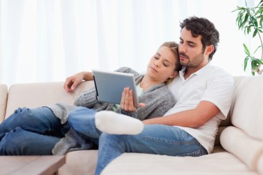 Lovely couple using a tablet computer clipart