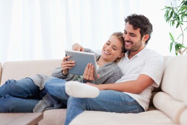 In love couple using a tablet computer clipart