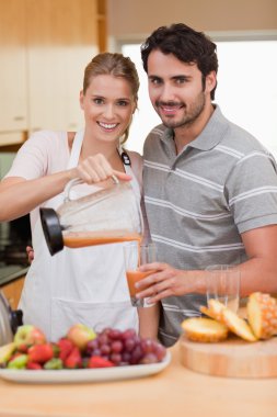 Portrait of a smiling couple drinking fruits juice clipart