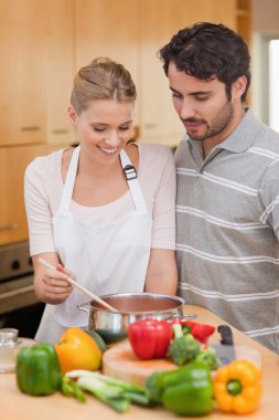 Portrait of a couple preparing a sauce clipart