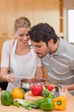 Portrait of a happy couple preparing a sauce clipart