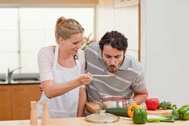 Young couple preparing a sauce clipart