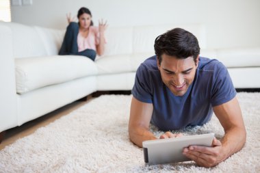 Man using a tablet computer while his girlfriend is getting mad clipart