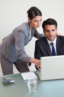 Portrait of a focused business team working with a laptop clipart