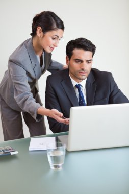 Portrait of a good looking business team working with a notebook clipart