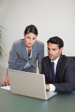 Portrait of sales persons working with a notebook clipart