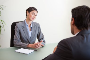 Manager interviewing a good looking applicant clipart