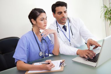 Young doctors working with a notebook clipart