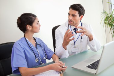 Young doctors working with a laptop clipart