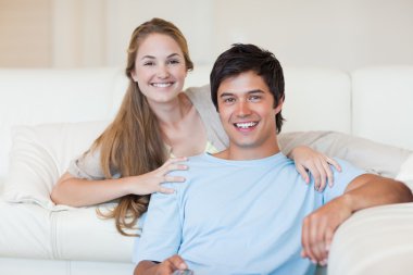 Smiling couple watching television clipart