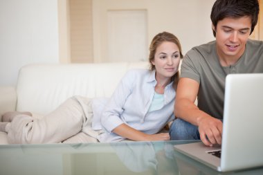 Relaxed couple using a laptop clipart