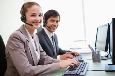 Young office workers using computers clipart