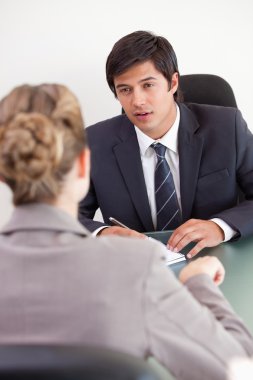 Portrait of a serious manager interviewing a female applicant clipart