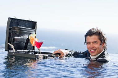 Businessman posing with a cocktail in a briefcase clipart