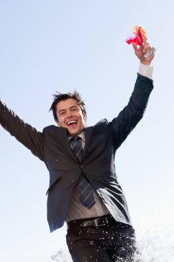 Portrait of a businessman jumping in a swimming pool clipart