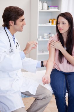 Male doctor about to give an injection to patient clipart