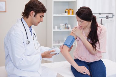 Doctor taking patients blood pressure clipart